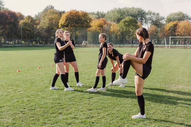 サッカーのフィールドでウォーミングアップの女性