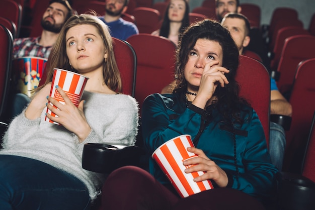 Women watching sad movie in cinema