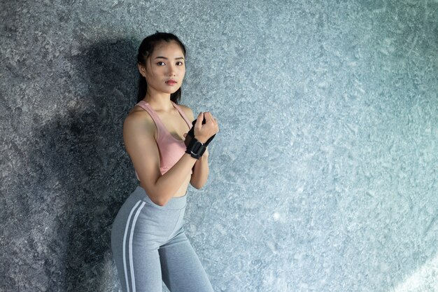 Women wear wristbands to exercise and stand against the wall.