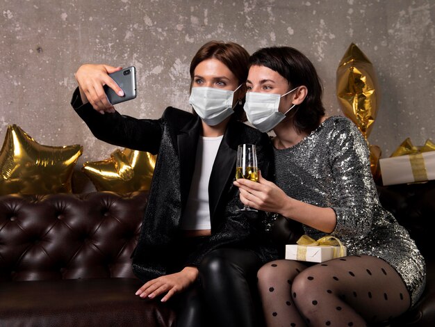 Women wearing face masks taking a selfie