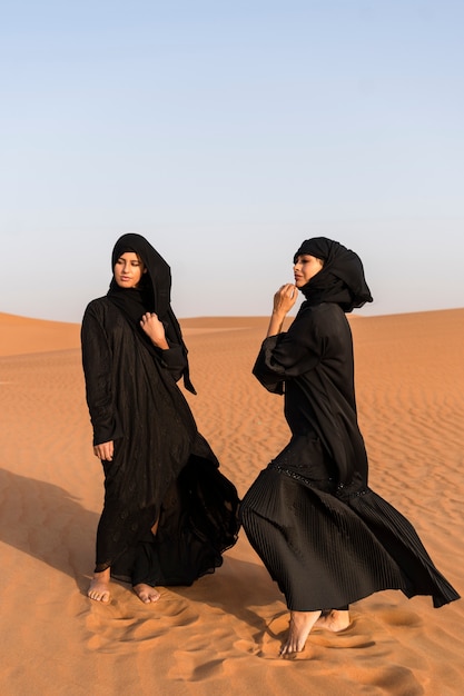 Free photo women wearing hijab in the desert