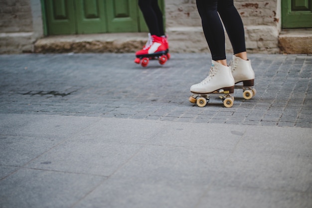 Women wearing rollerskates riding on pavement