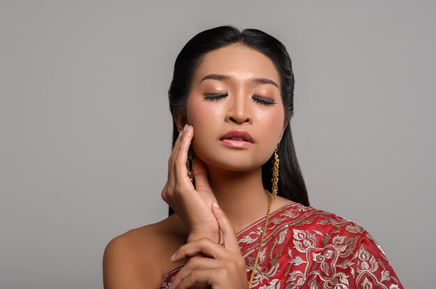 Women wearing Thai clothes and hands touching their faces