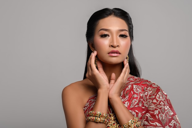 Women wearing Thai clothes and hands touching their faces