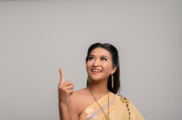 Free photo women wearing thai costumes that are symbolic, pointing fingers