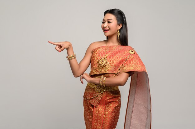 Women wearing Thai costumes that are symbolic, pointing fingers