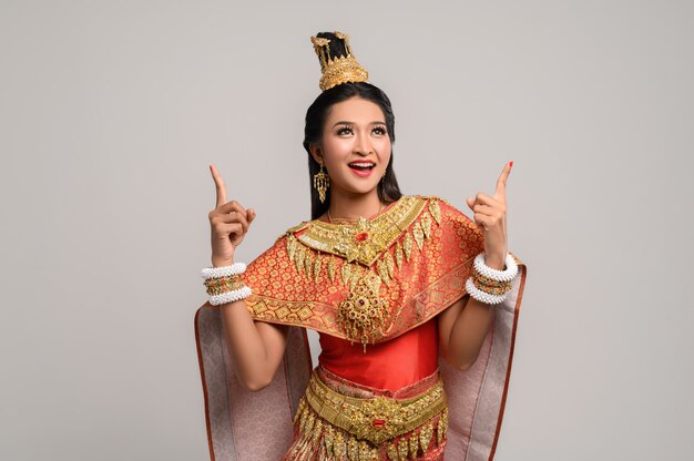 Free photo women wearing thai costumes that are symbolic, pointing fingers