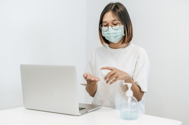 Women wearing white shirts that press the gel to wash hands to clean hands.