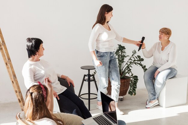 Women in white shirts talking on the microphone