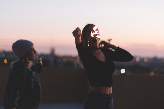 Women with beer and sparklers on roof