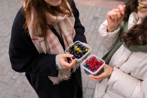 women with berries outdoors high angle