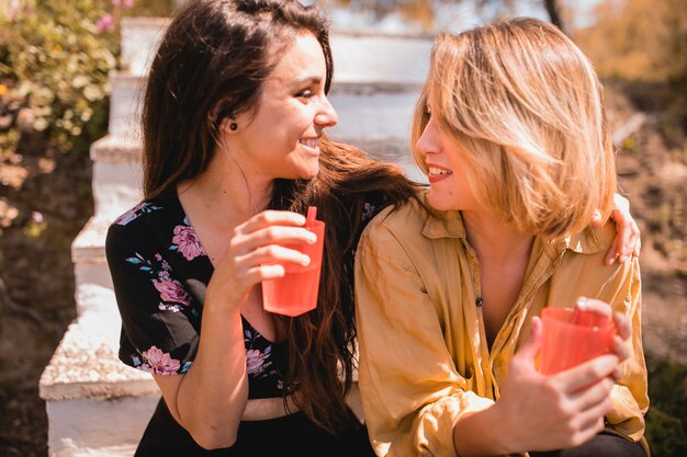 Women with beverages looking at each other