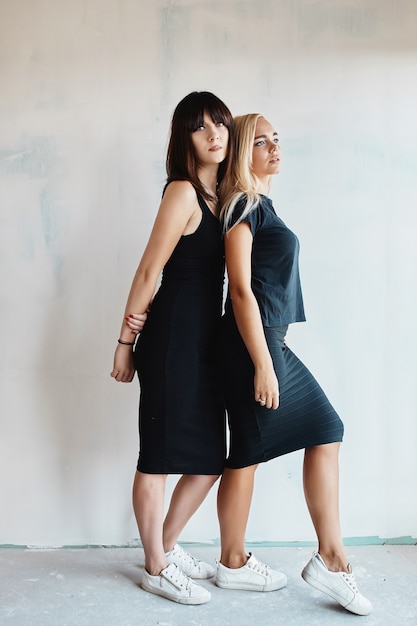 Women with black dress posing on wall