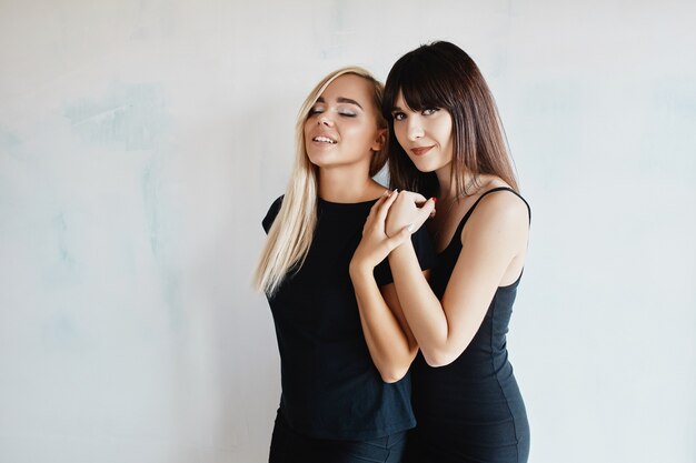 Women with black dress posing on wall