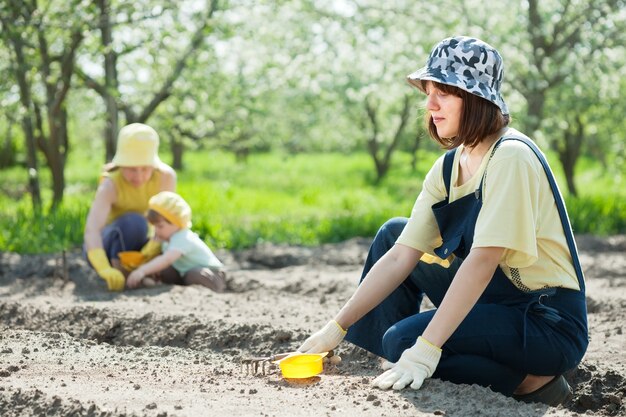 женщины с детьми работают на овощном саду
