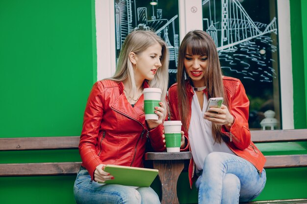 Women with coffee cups looking a mobile