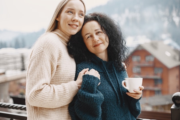 Women with a cup of coffee. Wonderful holiday in mountains. Snowy weather.
