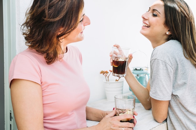 お互いを見て飲み物を持つ女性