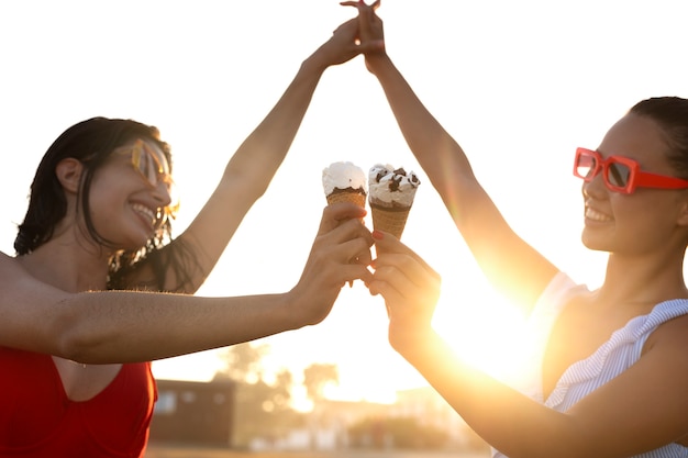 Foto gratuita donne con gelato alla vista laterale della spiaggia