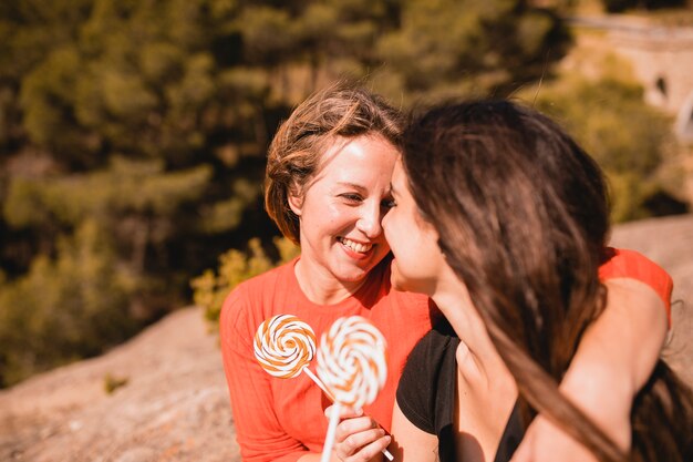 Women with lollipops looking at each other