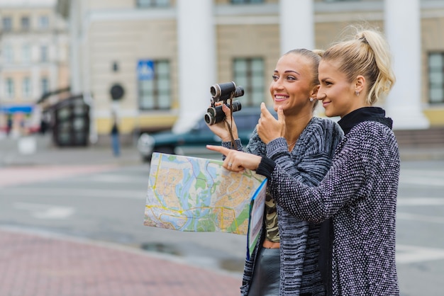 Women with map and binoculars together