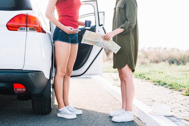 道路上の地図を持つ女性