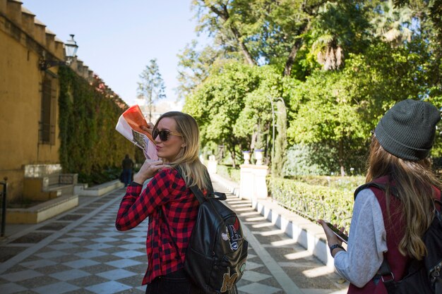 Women with map walking in beautiful park