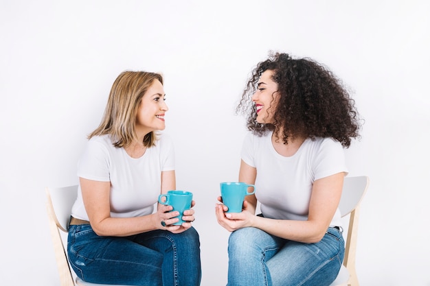 Women with mugs smiling and talking