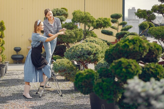 Women working in a greenhouse with green trees