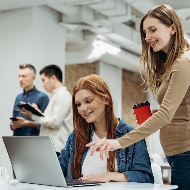 Foto gratuita donne che lavorano insieme a un progetto in ufficio