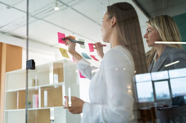 Women working with post-its side view