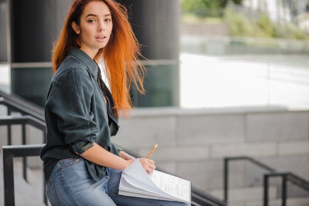 Womna with papers looking at camera