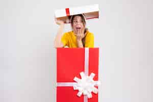 Free photo wondered girl with santa hat standing in big xmas giftbox on white