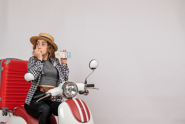 wondered young woman on moped holding up ticket on grey isolated