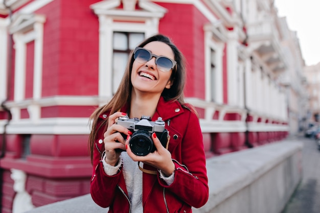 Wonderful brown-haired white woman laughing while posing with camera