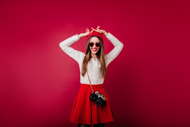 Wonderful caucasian girl in white sweater dancing with camera