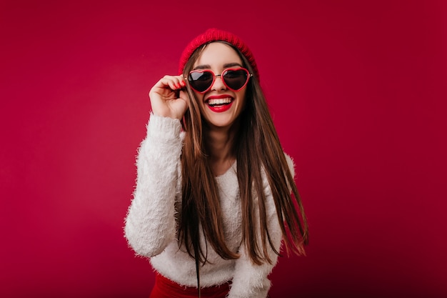 Wonderful girl in trendy heart glasses expressing good emotions