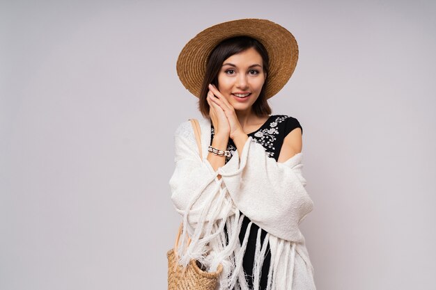 Wonderful short haired woman in straw hat and summer boho closes posing