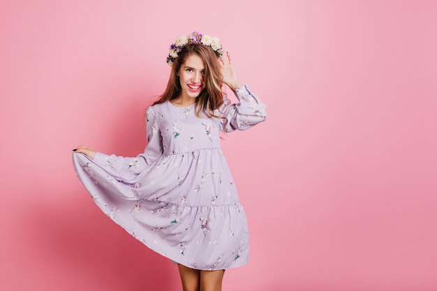 Wonderful white woman in vintage purple dress posing in studio