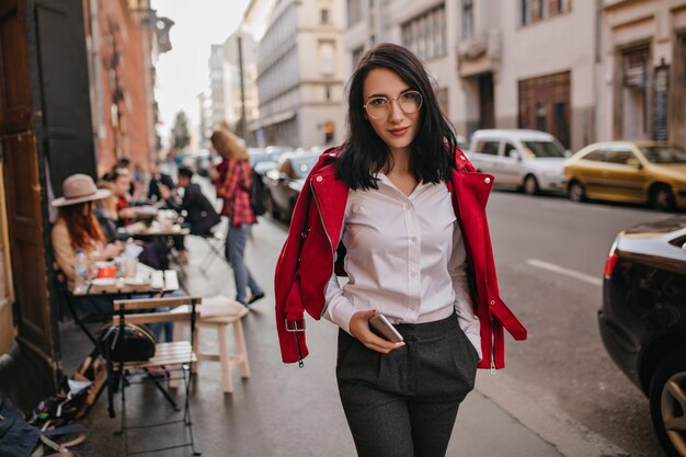 Wonderful young woman in formal attire walking down the street