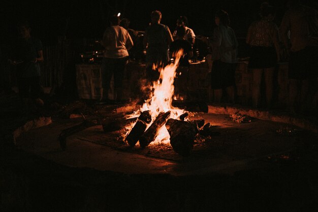 Wood burning in a late night campfire people