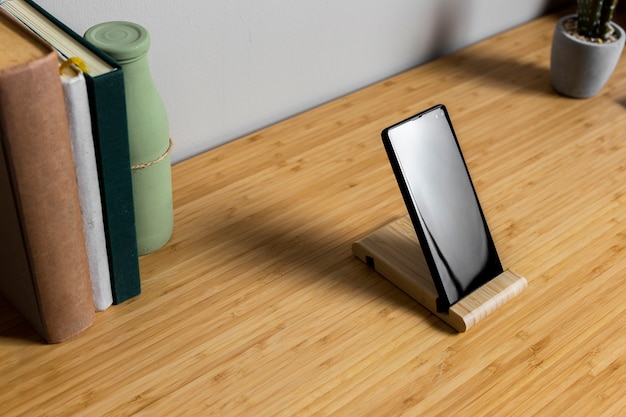 Wood desk with black smartphone and books