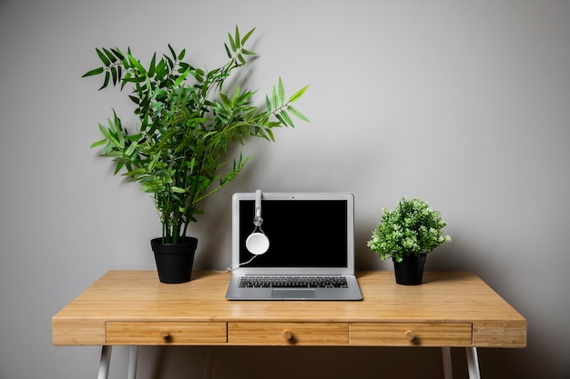 Wood desk with grey laptop and headphones