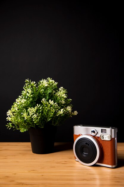 植物とカメラ付きの木製デスク