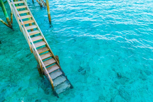 Деревянная лестница в море тропического острова Мальдивы.