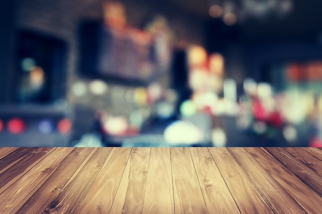 木製​の​テーブル​と​コーヒー​ショップ​の​背景​を​ぼかし
