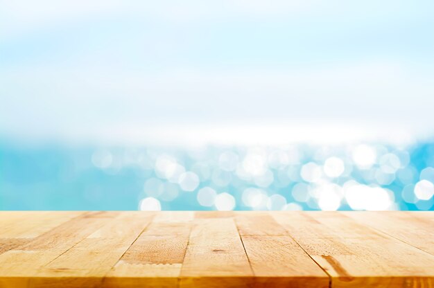 光沢のある海の水と夏の空の背景にぼかしの木のテーブルトップ プレミアム写真