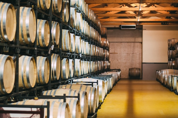 Wood wine barrels stored in a winery on the fermentation process