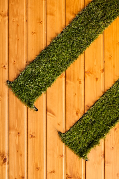 Wooden background with artificial grass