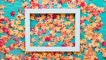 Free photo wooden background with autumn leaves and frame picture